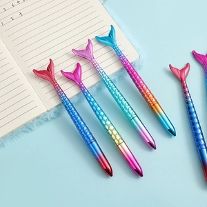 Flat lay of colorful mermaid tail gel pens with scale texture on blue background