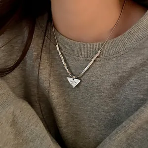 Collana in acciaio inox con pendente a triangolo e catena a maglie quadrate incise