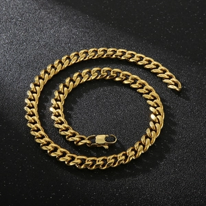 Detailed close-up of a bold gold Cuban link chain necklace with a lobster clasp closure