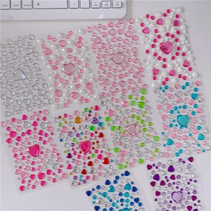 Flat lay of colorful acrylic heart and round gem stickers for DIY girl decorations