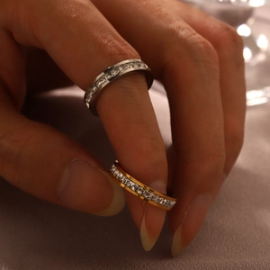 Close-up of eternity band rings in silver and gold with square cut zirconias on hand