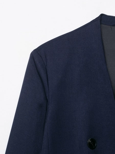 Macro view of navy blue blazer fabric texture with shoulder stitching and collar details