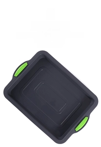 Detailed view of dark grey silicone brownie mold with green handles for oven use