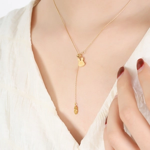 Gold 18K plated stainless steel bunny and carrot pendant necklace on a white shirt