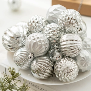 Boules de Noël argentées aux motifs géométriques et rayés sur une assiette blanche