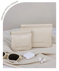 Macro view of beige faux leather portable storage bags with golden auto-close metal clips
