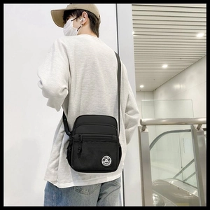 Practical black nylon messenger bag shown on model for realistic size and fit perspective