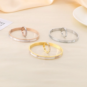 Detail of shell inlay bangles and rings set in rose gold, silver, and gold finish