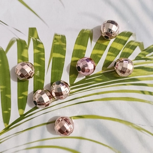 Detail of rose gold faceted beads for DIY jewelry with clear holes on white background