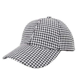 Detail view of stylish black and white houndstooth fabric texture on a baseball cap