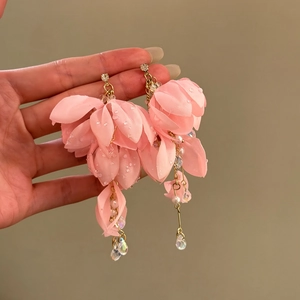 Detailed close-up view of pink fabric flower earrings with pearls and crystal beads