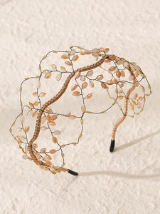 Dettaglio del cerchietto fatto a mano con perle di cristallo arancioni e design a vite