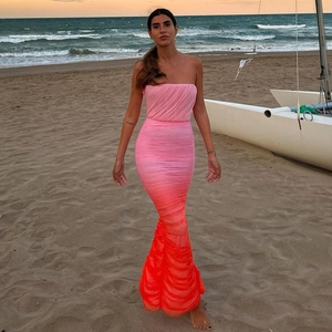 Detail eines eleganten, rosa Netz-Abendkleides mit Farbverlauf am Strand bei Sonnenuntergang