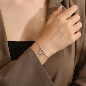 Gros plan du bracelet cœur en argent minimaliste avec zircons au poignet du mannequin