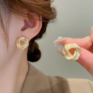 Minimalist twisted geometric golden stud earrings with a brushed metal texture finish