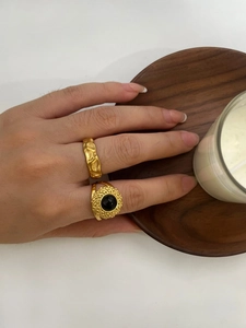 Detail view of 18K gold plated ring set with vintage black stone on a female hand