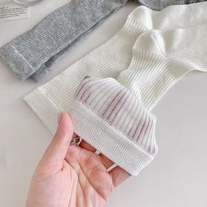 Detailed close-up of grey and white ribbed knit socks showing thin breathable mesh fabric
