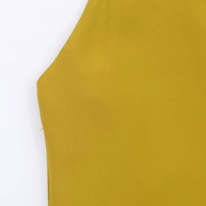 Macro detail of mustard yellow knit fabric texture and high-quality stitching on halter top