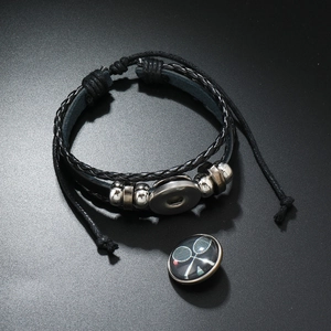 Vue détaillée d'un bracelet en cuir tressé avec bouton pression motif tennis et perles