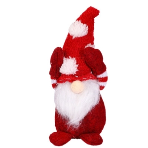 Cute Christmas gnome doll with red snowflake hat and white beard on a plain background