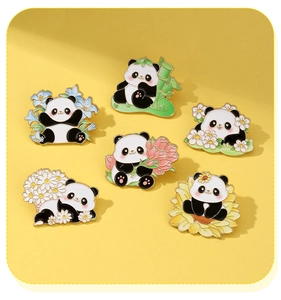 Close-up of cute cartoon panda enamel pins featuring bamboo and flowers on yellow background