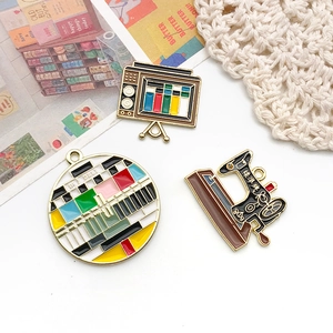 Macro shot of retro enamel charms featuring a classic TV and vintage sewing machine