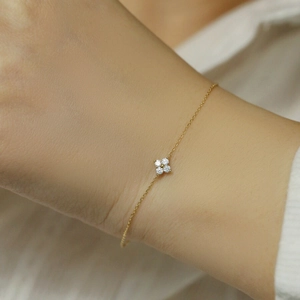 Close-up of a 14K gold plated silver clover pendant with diamonds on a delicate chain