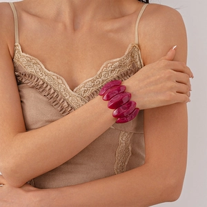 Nahaufnahme eines klobigen rosa Marmor-Acryl-Armbands im Vintage-Stil am Handgelenk eines Models