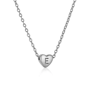 Macro shot of polished silver heart pendant with letter E engraving on link chain