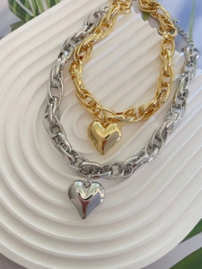 Detail of chunky Cuban link necklaces with 3D heart pendants in gold and silver finish
