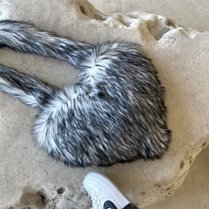 Detail view of the black and white faux fur crossbody crescent bag with fuzzy strap