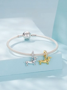 Macro shot of silver and gold dachshund charms with sparkling zircon on S925 bracelet