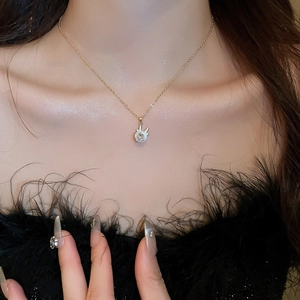 Close-up of golden rabbit pendant necklace with zircon stone on model neck