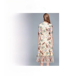 Macro detail of elegant embroidery and floral patterns on ivory mesh midi dress
