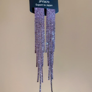 Detailed macro view of silver needle purple tassel earrings with sparkling rhinestones