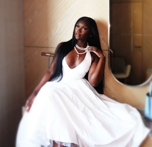 Detail of elegant white deep V-neck sleeveless dress with layered pearl necklace