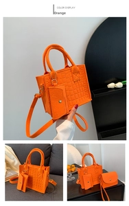 Detail view of orange crocodile pattern tote bag with shoulder strap and mini pouch