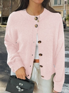 Détail du cardigan en maille rose avec col rond et boutons foncés à l'avant