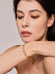 Detailed close-up of 18K gold plated pearl bangle with elegant wavy C-shaped design
