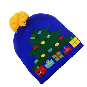 Close-up of blue knitted Christmas hat with LED lights, tree patterns and yellow pompom