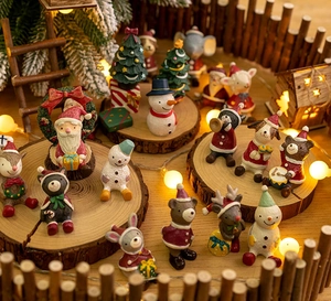Detailed close-up of colorful resin Christmas miniature figurines on a rustic wood slice