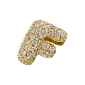 Macro shot of gold-plated letter F pendant encrusted with sparkling cubic zirconia stones