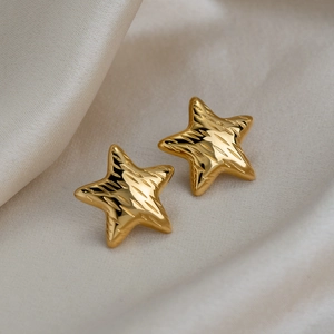 Detail of 18K gold-plated stainless steel star studs with elegant textured finish