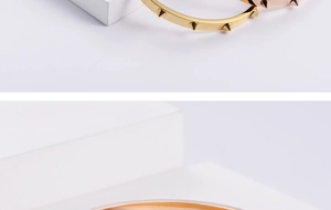 Detail view of gold and rose gold metal bracelets with rivet design and stud details