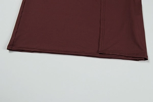 Close-up of the double-needle stitched hem on a burgundy long-sleeved knit dress