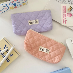 Close-up of quilted macaron-colored stationery bags with cartoon puppy branding