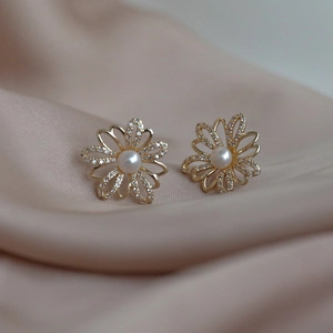 Detailed view of S925 floral earrings with white pearls and sparkling cubic zirconia