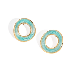 Vue macro de boucles d'oreilles rondes dorées avec texture marbre turquoise et émail
