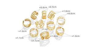 Detalle de diez anillos variados de acero de titanio chapado en oro con diseños geométricos