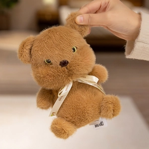 Cute brown plush teddy bear with green eyes and white decorative ribbon toy